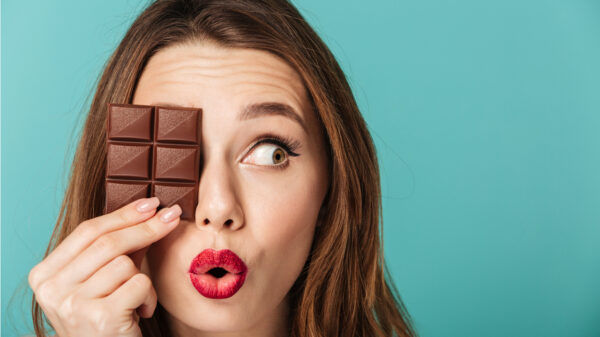 Mulher com uma barra de chocolate escondendo os olhos