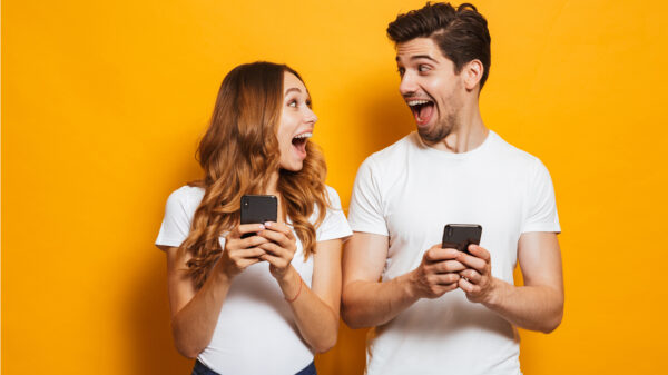 Homem e mulher felizes com celular na mão