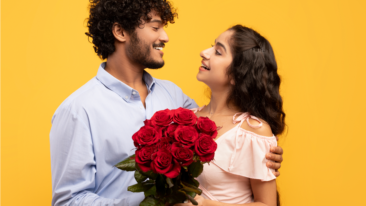 Homem dá buquê de rosas para mulher