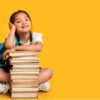meninas com livros escolar em fundo amarelo