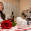 casal jantando com rosa vermelha e velas