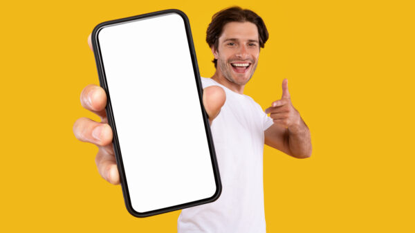 homem feliz segurando um celular em fundo amarelo