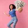 mulher dando pulos de alegria com dinheiro na mão