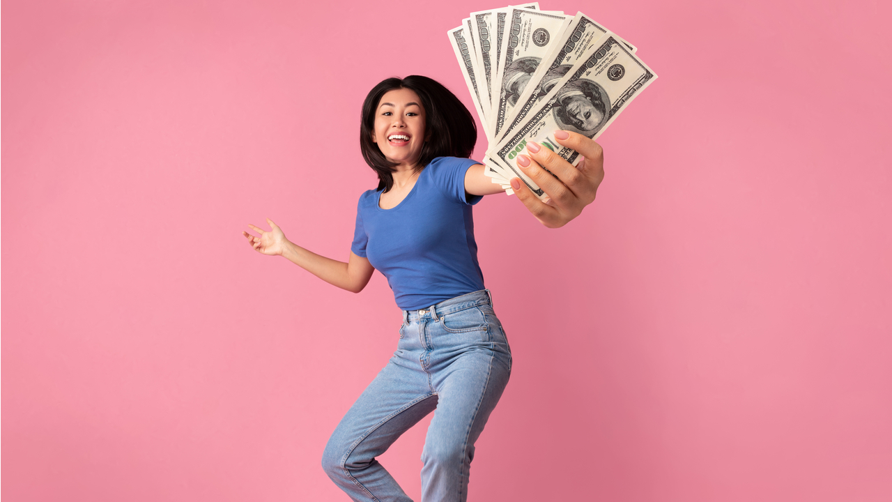 mulher dando pulos de alegria com dinheiro na mão