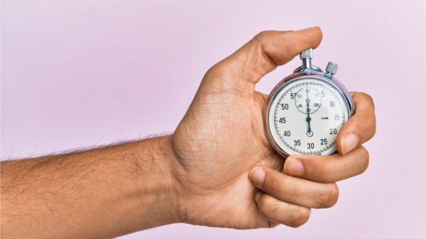 Mão de jovem usando cronômetro sobre fundo lilás isolado.