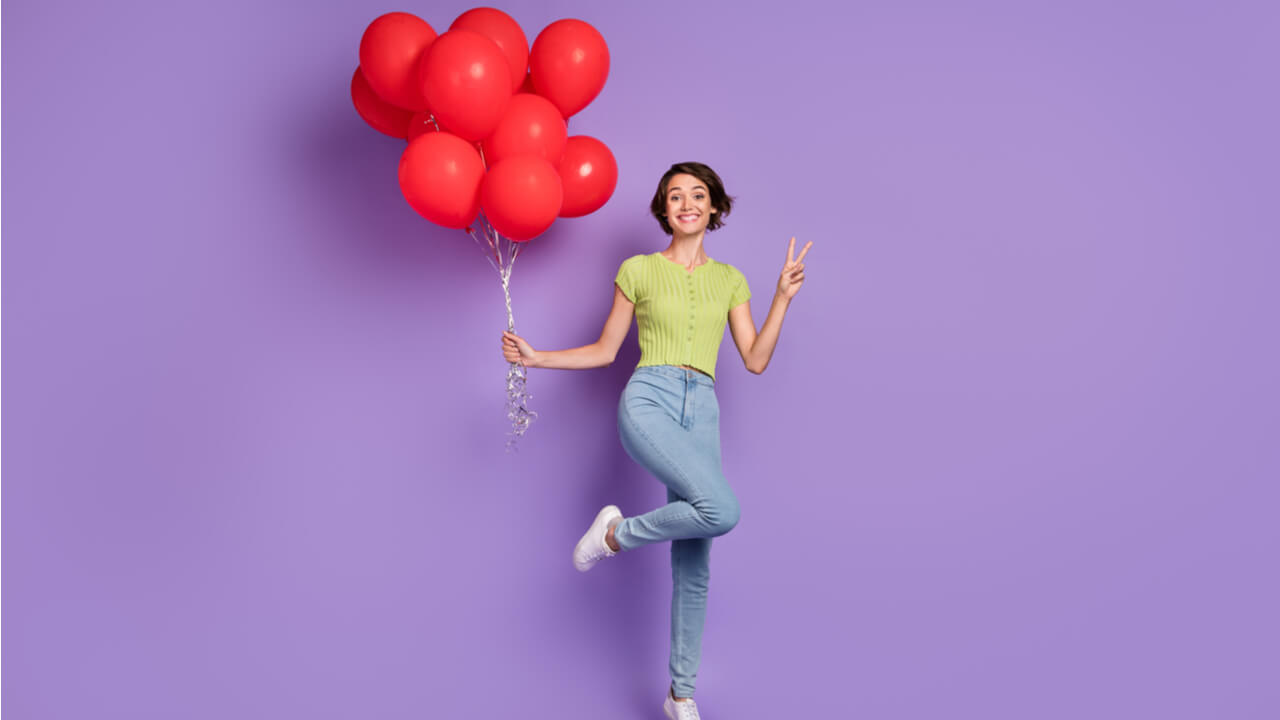 mulher feliz com balões nas mãos