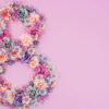 número 8 feito em flores em um fundo lilás