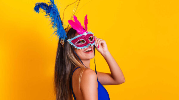 Mulher vestida para carnaval. Mulher sorrindo e pronta para curtir o carnaval, com máscara.