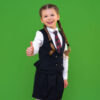 Menina alegre usando um uniforme escolar em um fundo isolado.