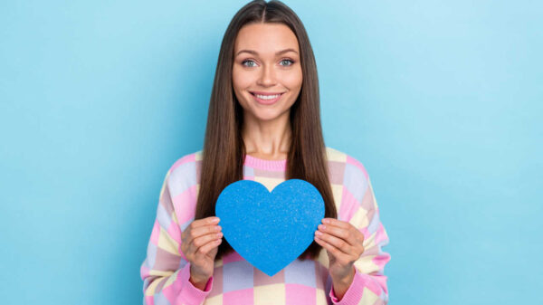 mulher segurando um coração azul em fundo azul