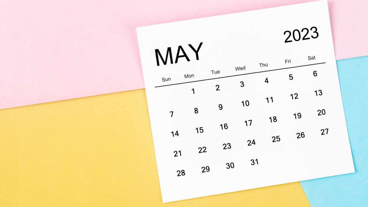Calendário mensal de maio de 2023 em fundo colorido.