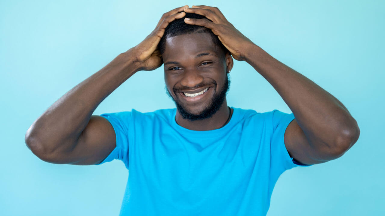 Homem rindo. Conceito de emoção positiva. Retrato de um homem muito feliz feliz otimista, rindo, isolado em um fundo azul de um estúdio.