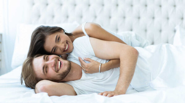 casal deitado na cama sorrindo