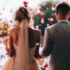 casal saindo da igreja casados com pétalas de rosas vermelhas