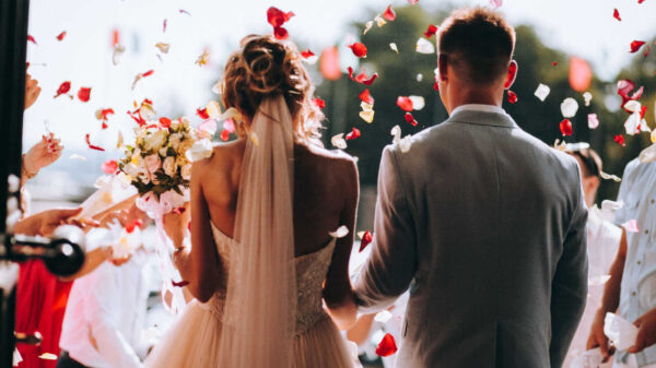 casal saindo da igreja casados com pétalas de rosas vermelhas