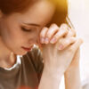 mulher ajoelhada rezando