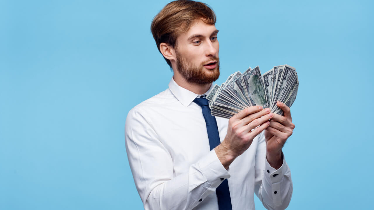 Homem de camisa com gravata contando notas de dinheiro.
