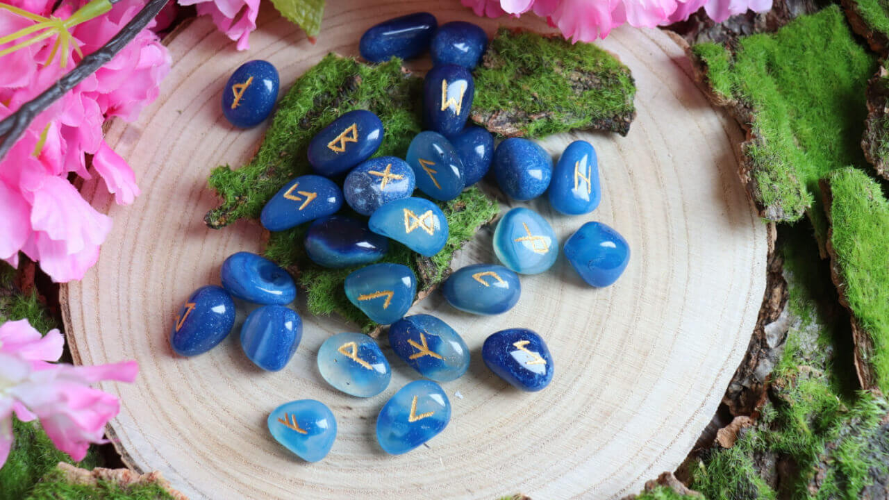 pedras de runas na cor azul em cima de uma mesa de madeira maciça
