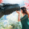 imagem de fantasia onde uma princesa de vestido verde toca no queixo de um dragão