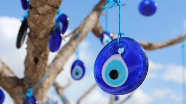 pingentes de olho grego penduradas em uma árvore em um céu azul