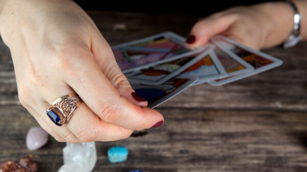 mulher segurando uma baralho de cartas de tarot