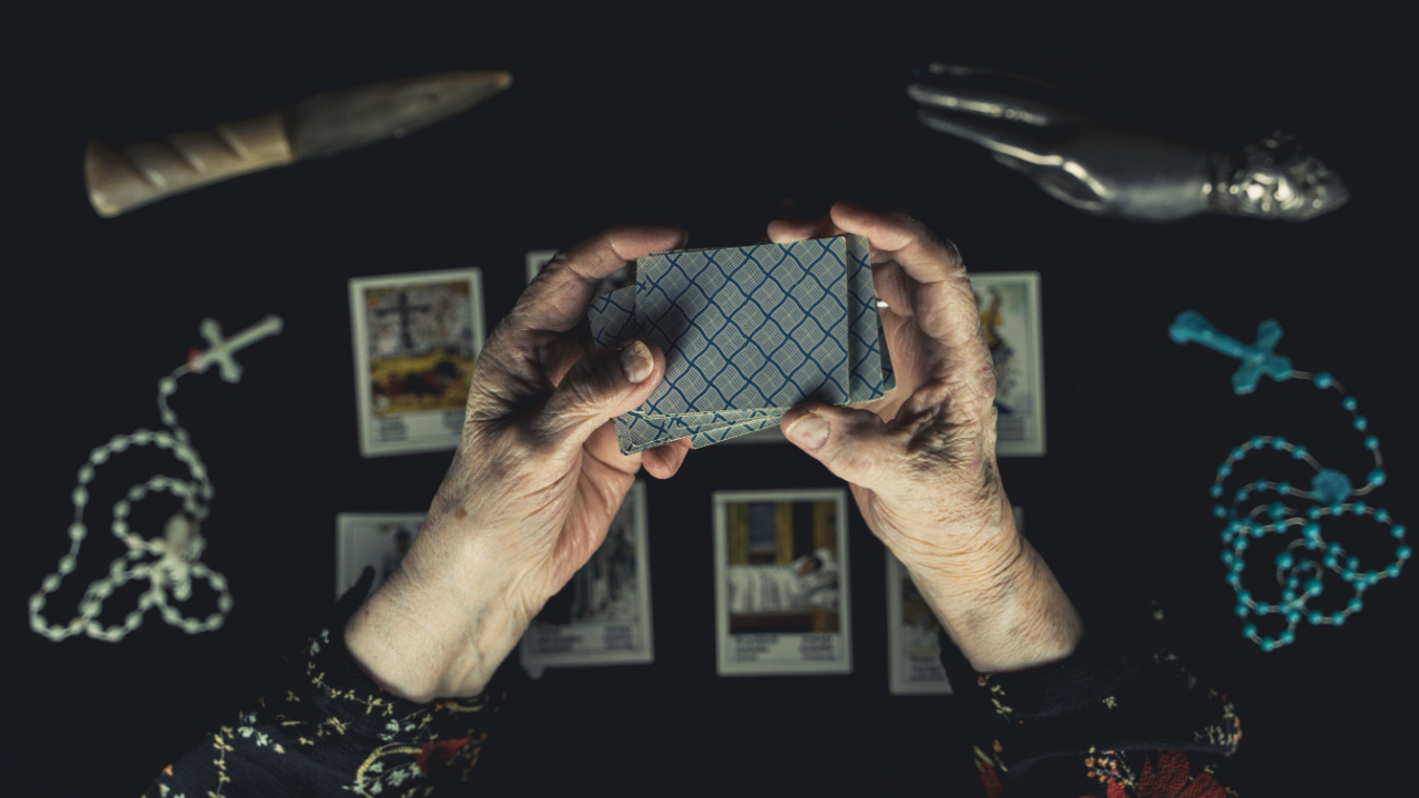 foto de uma mão segurando as cartas do baralho cigano