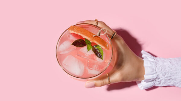 copo com um drink visto de cima em fundo rosa