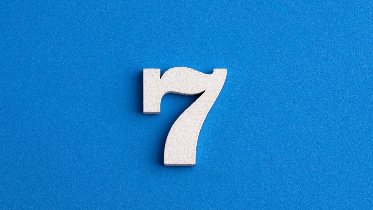 Número sete branco em um fundo azul.