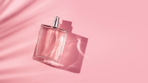 vidro quadrado e transparente de perfume em fundo rosa