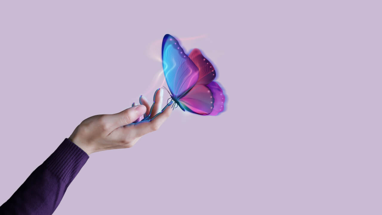 Uma borboleta feita por meio de computação gráfica pousando na mão de uma pessoa.