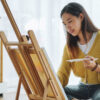 mulher de traços asiáticos pintando uma tela