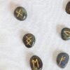 Conjunto de pedras rúnicas para adivinhação e leitura da sorte. Natureza morta mística com runas de labradorita. Conceito de esoterismo, de ocultismo e de bruxaria.