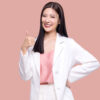 mulher fazendo sinal de positivo com o dedão em fundo rosa