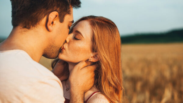 casal hétero se beijando em um campo a céu aberto