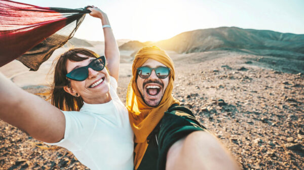 casal hetero felizes viajando no deserto