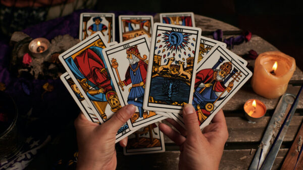 par de mãos segurando cartas de tarot