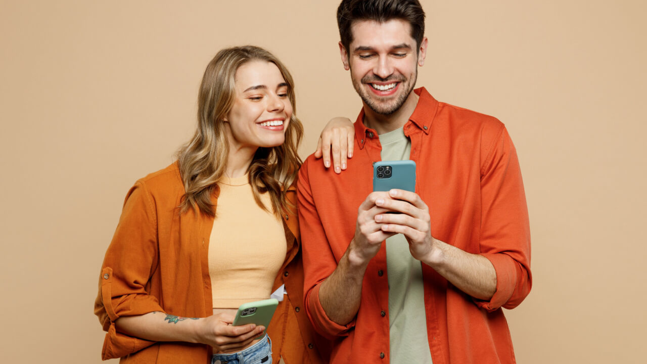 homem e mulher brincando no celular