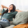 mulher sentada em um sofá em posição de estar relaxada