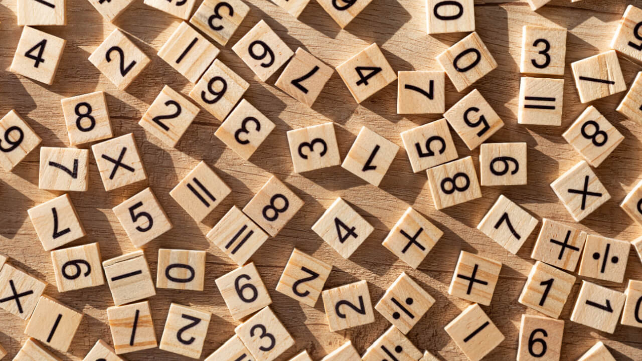 vários números gravados em bloquinhos de madeira em cima de uma mesa de madeira