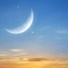 Lua nova, nuvens e pôr do sol em um céu azul.