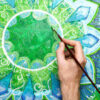 Homem pintando uma mandala verde brilhante, de anahata chakra.