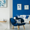 foto de uma sala com a parede da esquerda branca e a parede da direita azul escuro e as decorações também na cor azul