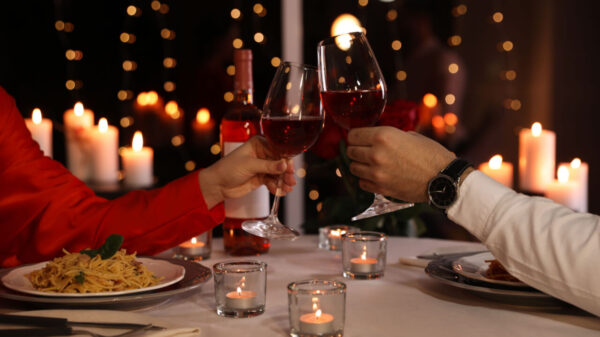 duas taças de vinho brindando em um jantar romantico
