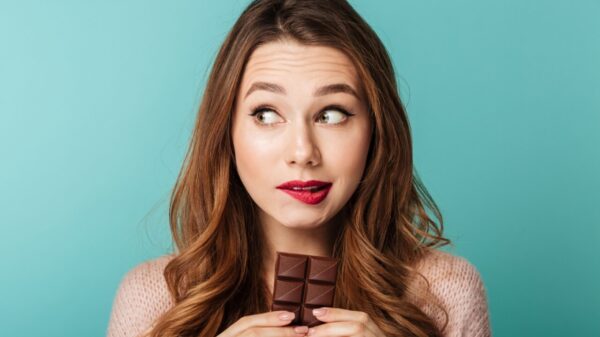 mulher em dúvida de comer chocolate