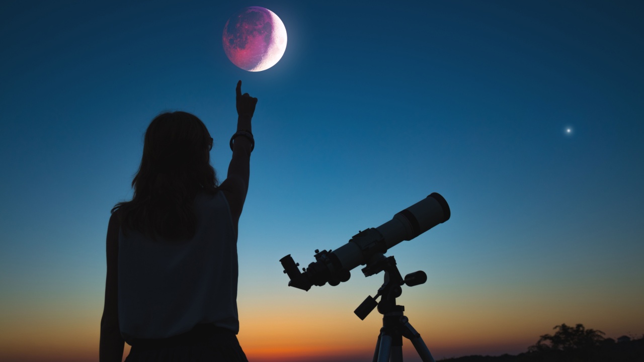 fotografia de uma menina ao lado de um telescópio e apontando para um eclipse lunar