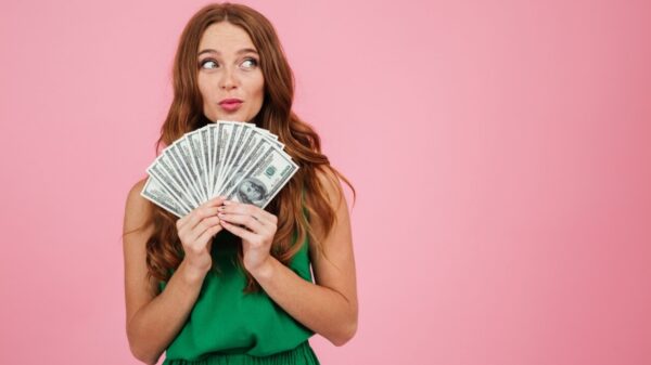 Retrato de uma mulher de cabelo longo segurando notas de dinheiro.