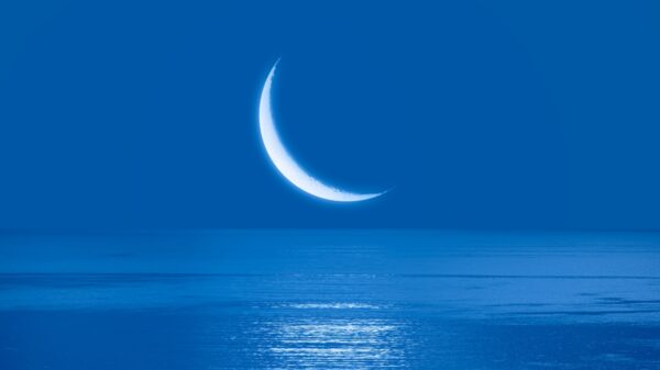 imagem da lua próxima ao horizonte do mar