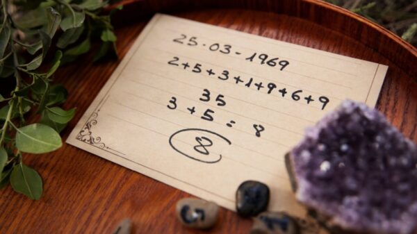 papel amarelado escrito uma sequencia de números onde o número oito está em destaque e o papel está em cima de uma mesa de madeira com um cristal roxo do lado