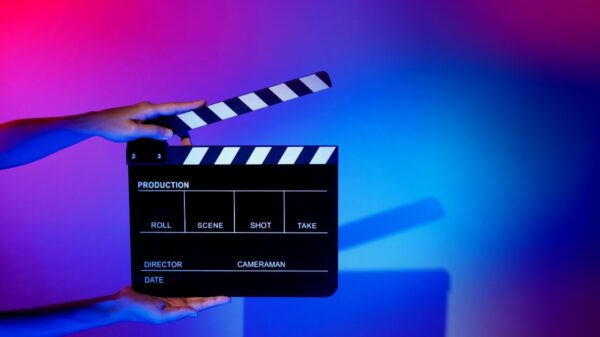 Imagem de uma claquete. Mão segurando claquete de produção de filme em um fundo colorido em um estúdio para filmagem ou gravação de filme.