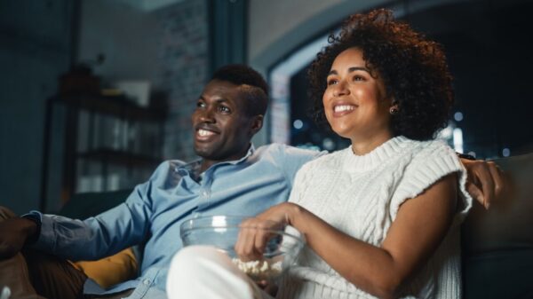 homem e mulher felizes assistindo TV e comendo pipoca